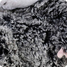 A close-up view of the black and gray textured faux fur on the back of the Opossum by Warmies stuffed animal.