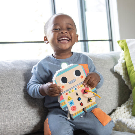 Child holding a colorful toy on a couch