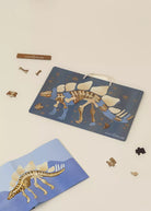 Dinosaur skeleton puzzle with packaging on a beige background