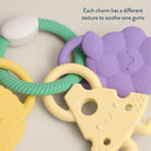 Teething ring with colorful charms on a neutral background