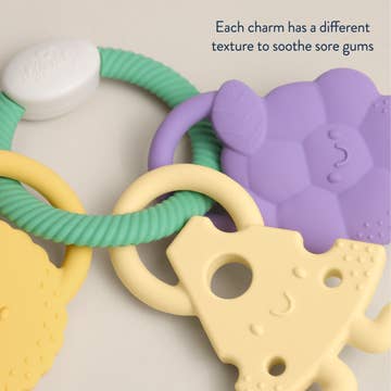 Teething ring with colorful charms on a neutral background