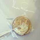 Decorative lollipop with gold and white design, branded 'Sweet Caroline Confections'.
