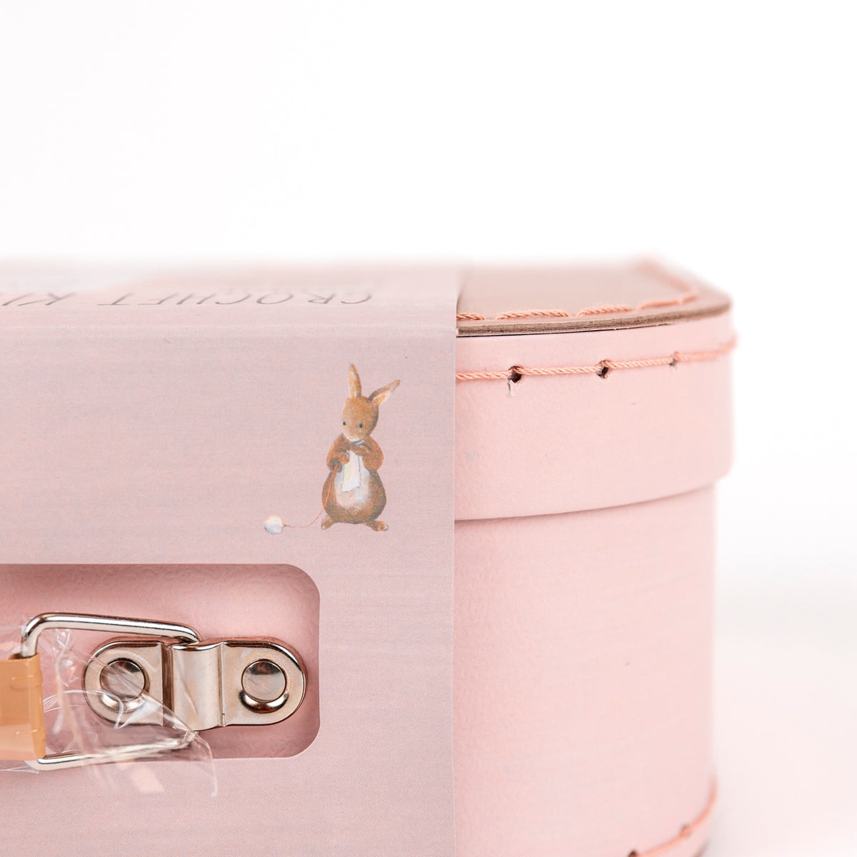 Pink suitcase with a small rabbit design on a white background