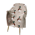 Blanket with duck pattern draped over a chair on a white background