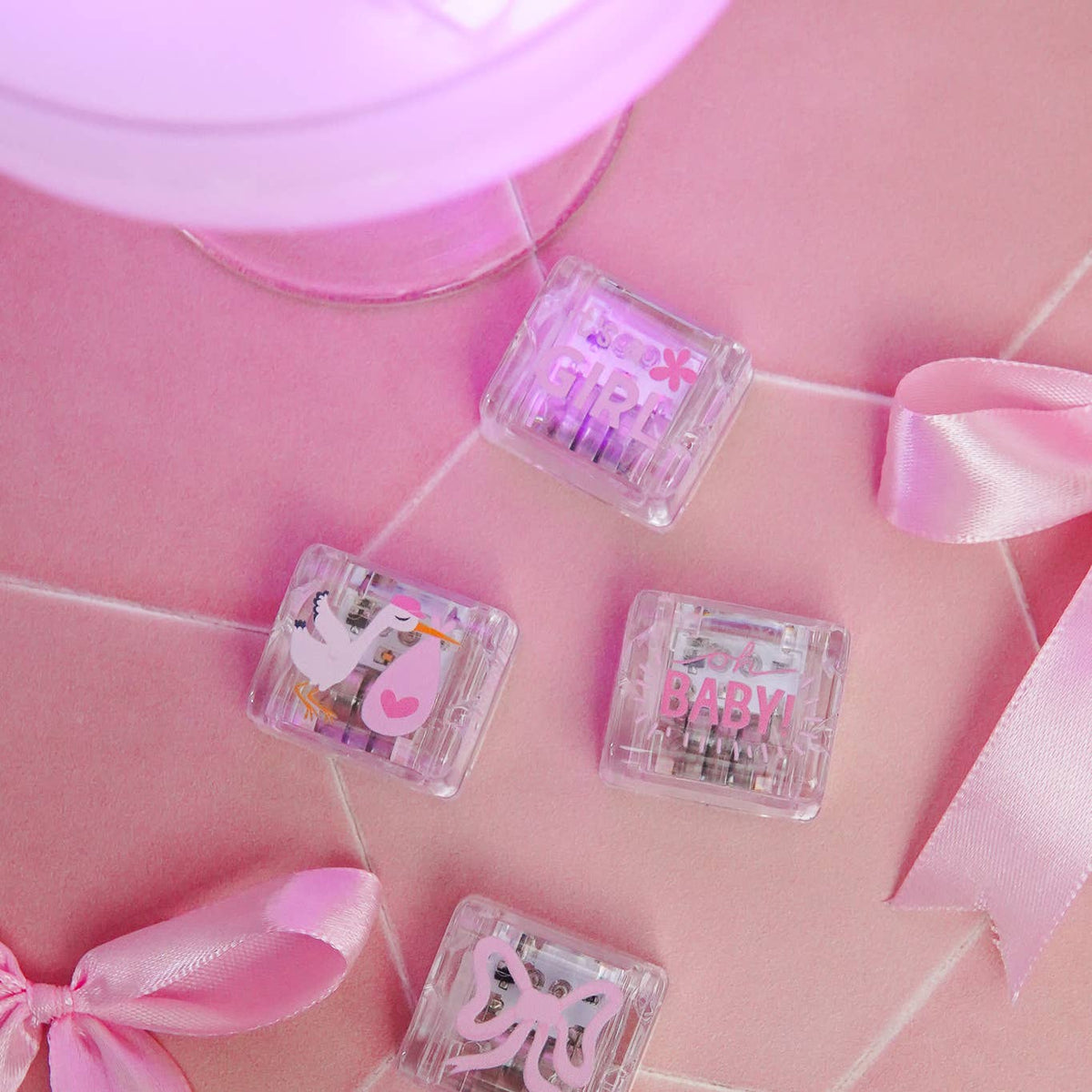 Clear nail art stamping plates with designs on a pink background