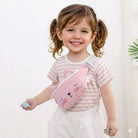 Child wearing a pink cat-shaped fanny pack against a white background