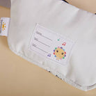 Baby bib with name tag and cartoon character on a beige background