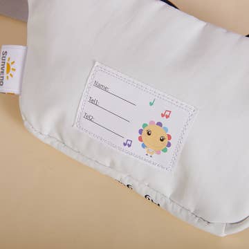 Baby bib with name tag and cartoon character on a beige background