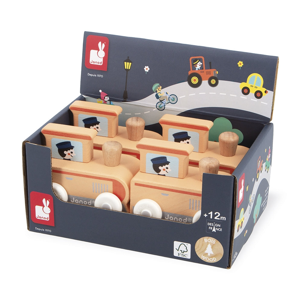 A retail display box of wooden Janod toy trains, featuring multiple natural wood trains with orange roofs and illustrated windows, set against a clean white background.