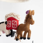 Collage of felt horse and barn decorations on a white background
