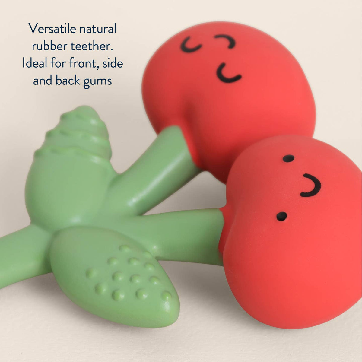 Two colorful rubber teething toys with smiling faces on a beige background.