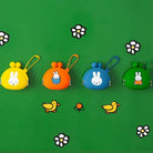Four colorful coin purses with cartoon characters on a green background with flowers and birds.