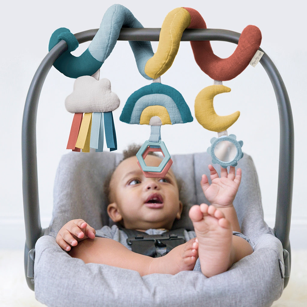 Baby in a bouncer with colorful hanging toys