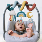 Baby in a bouncer with colorful hanging toys