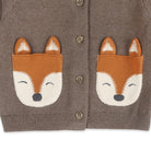 A close-up of a brown knit cardigan with two fox face patches on the chest and brown buttons, shown against a plain white background.