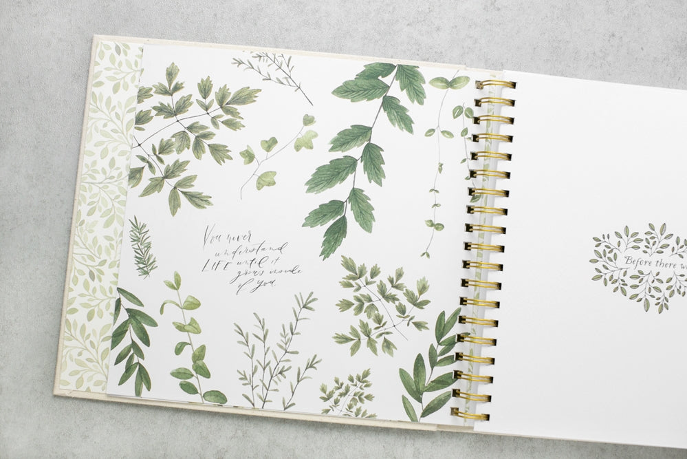 Open notebook with green leaf patterns on a gray surface