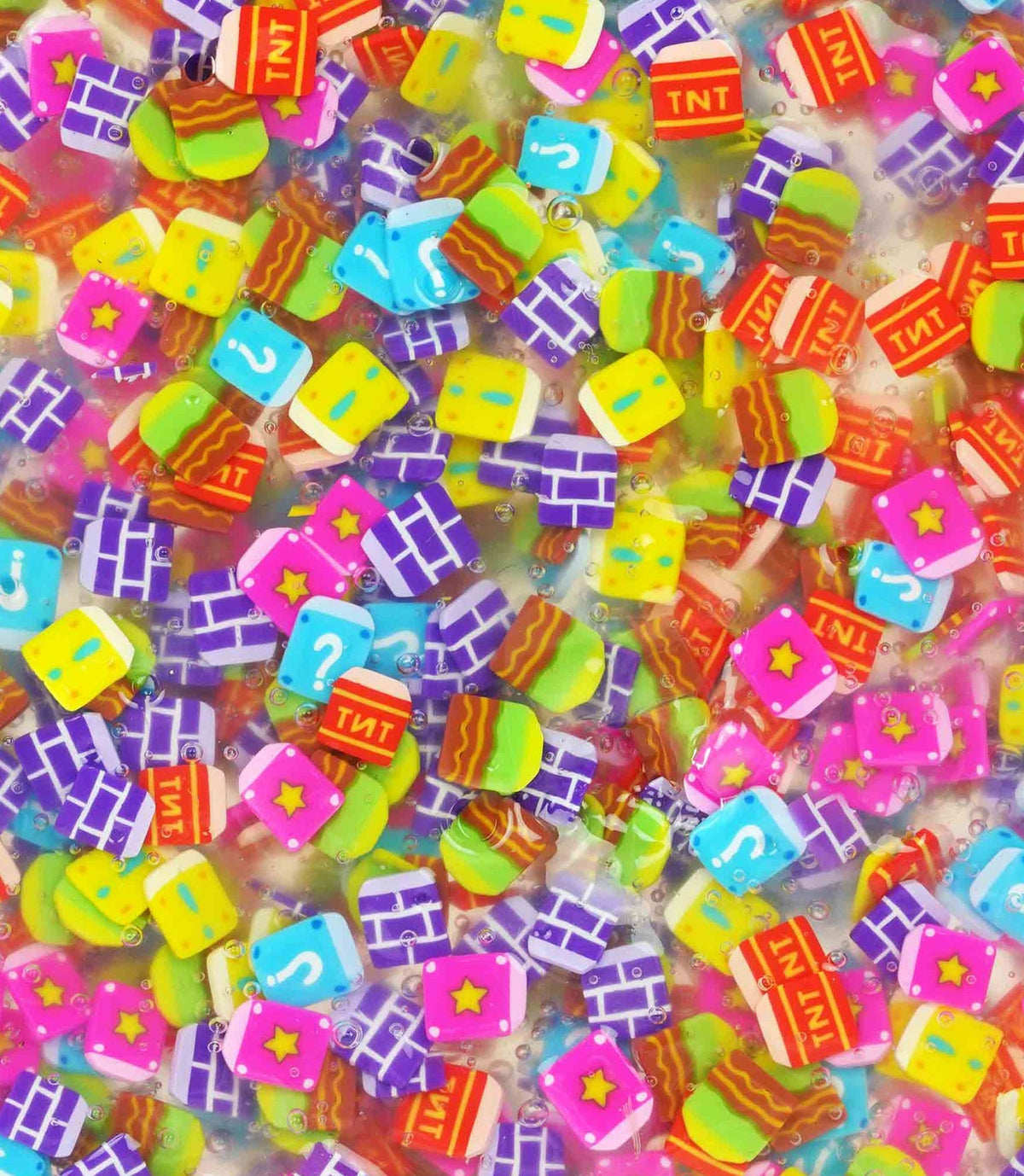 Colorful assortment of small, square-shaped charms with various designs on a pink background.