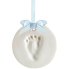 White ceramic ornament with baby footprint and light blue ribbon on a white background.