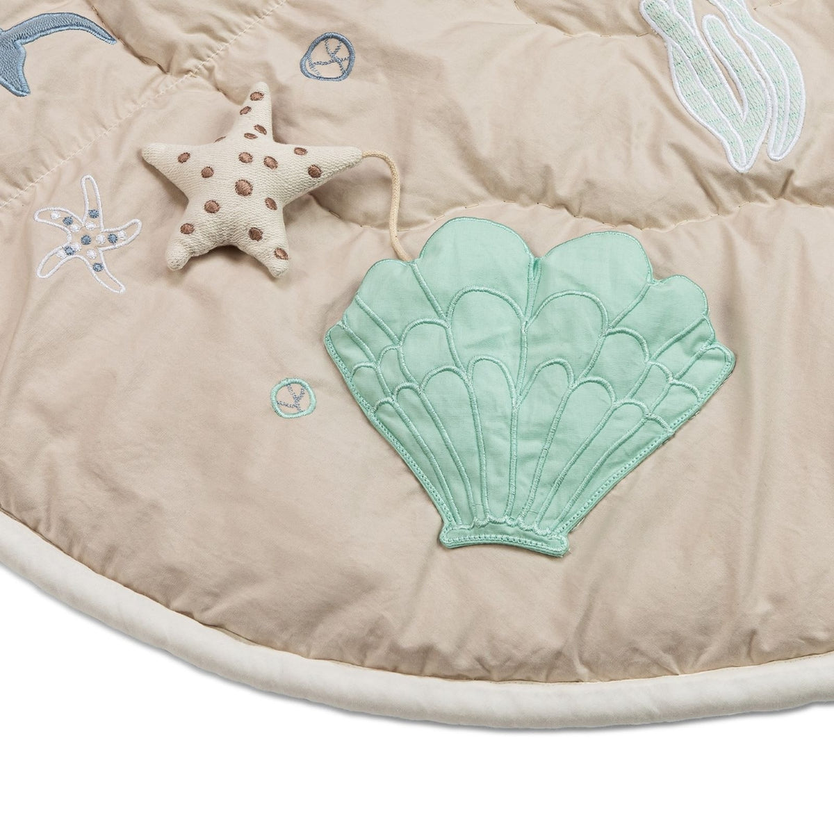 Beige play mat with green shell design and starfish decorations on a white background