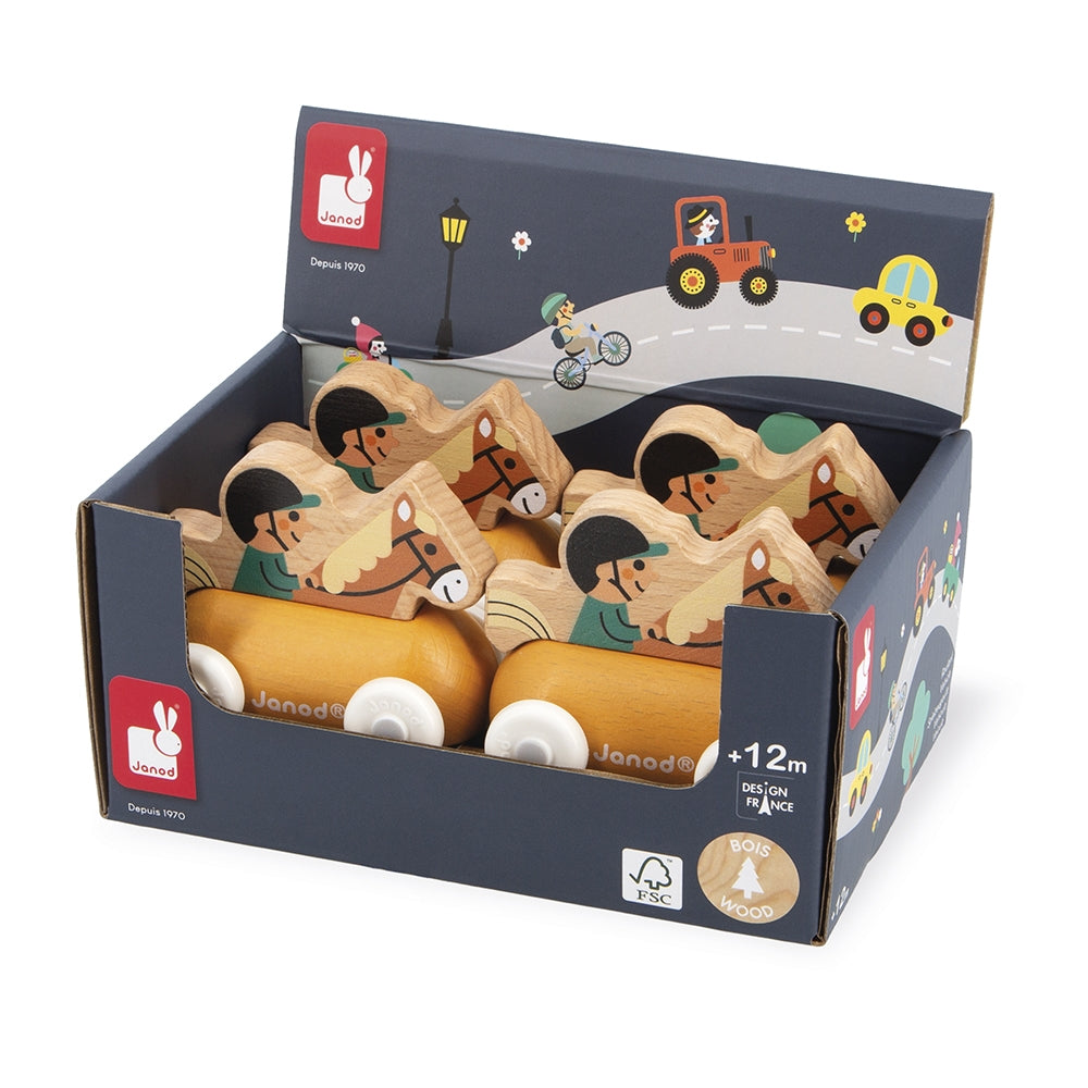 A retail display box filled with wooden Janodé toy cars, shown on a clean white background. The navy blue packaging features colorful illustrations of children's activities and the Janod bunny logo.