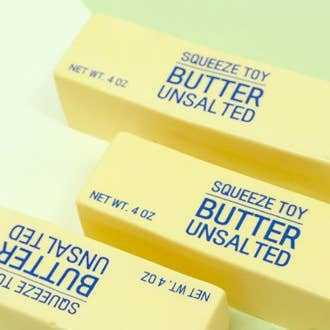 Three yellow squeeze toys labeled 'Butter Unsalted' on a light green background