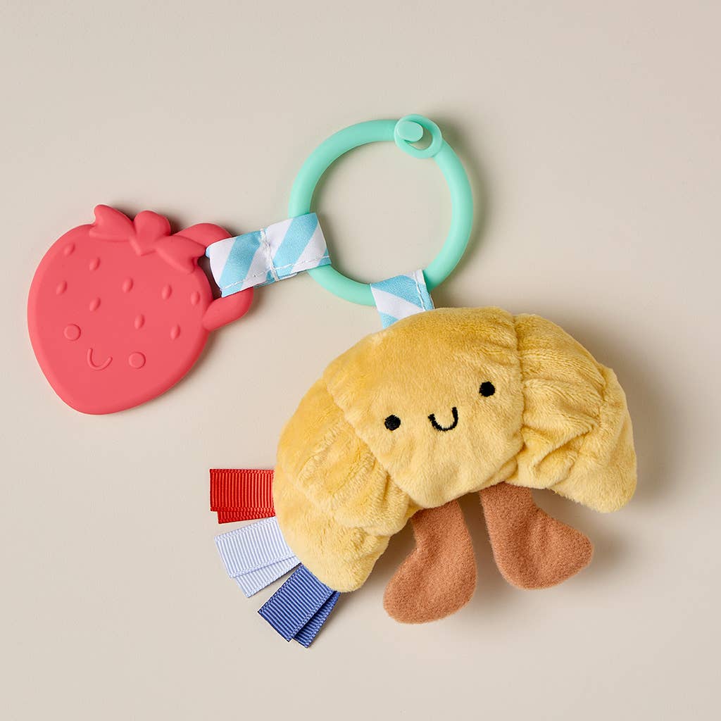Yellow plush toy with a strawberry teether on a beige background