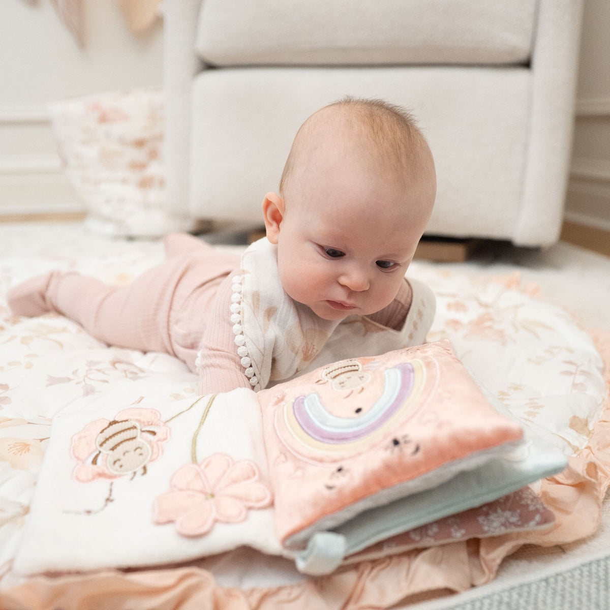 Baby lying on a soft surface with a colorful book