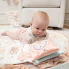 Baby lying on a soft surface with a colorful book