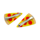Two triangular hair clips with red polka dots on a yellow background.