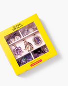 A yellow Super Smalls 'Mozzi's Purple' bead kit box, shown at an angle on a white background. The box has a clear window displaying various purple and lavender beads, crystals, and a small horse-shaped bead.