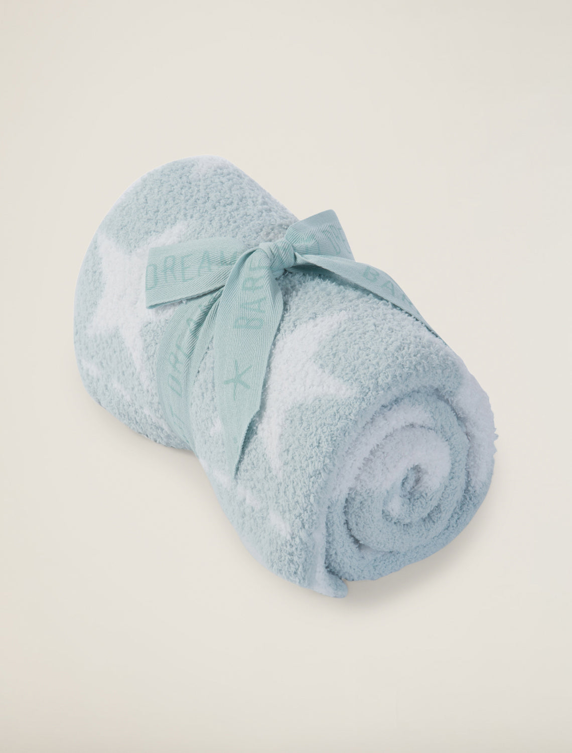 Rolled-up light blue towel on a beige background