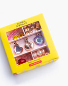 A yellow Super Smalls bead kit box, shown at an angle on a white background. The box has a clear window displaying various purple and lavender beads and crystals bead.