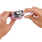 Pink toy with googly eyes being opened by a hand using tweezers on a white background