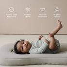 Baby lying on a cushion with product features listed above.