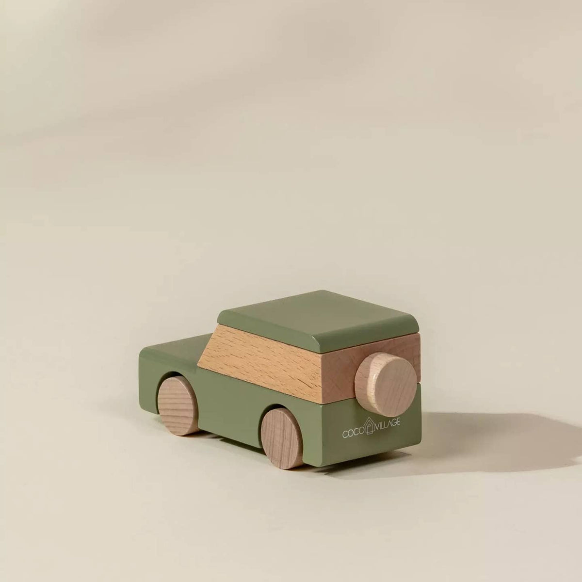 Wooden toy car with green and brown colors on a beige background