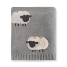 Gray knitted blanket with sheep designs on a white background