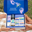Open box of Motherlove baby care products held by hands with a grassy background.