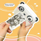 Panda-shaped photo printer with a printed photo held by hands against a yellow background