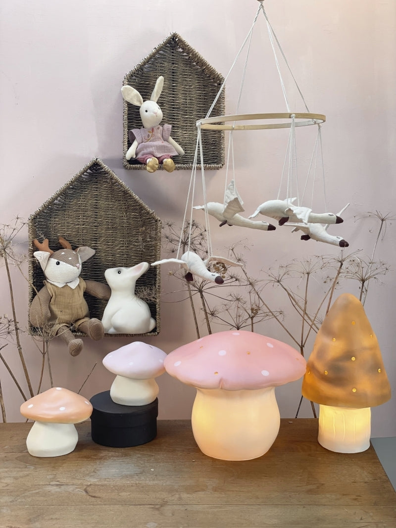 Set of mushroom-shaped lamps on a wooden surface with decorative animals in the background.