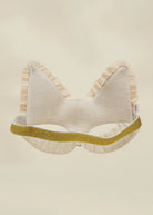 A cream-colored cat ear headband with vertical stripes, featuring a textured gold glitter band and ruffled trim, shown against a solid cream background.