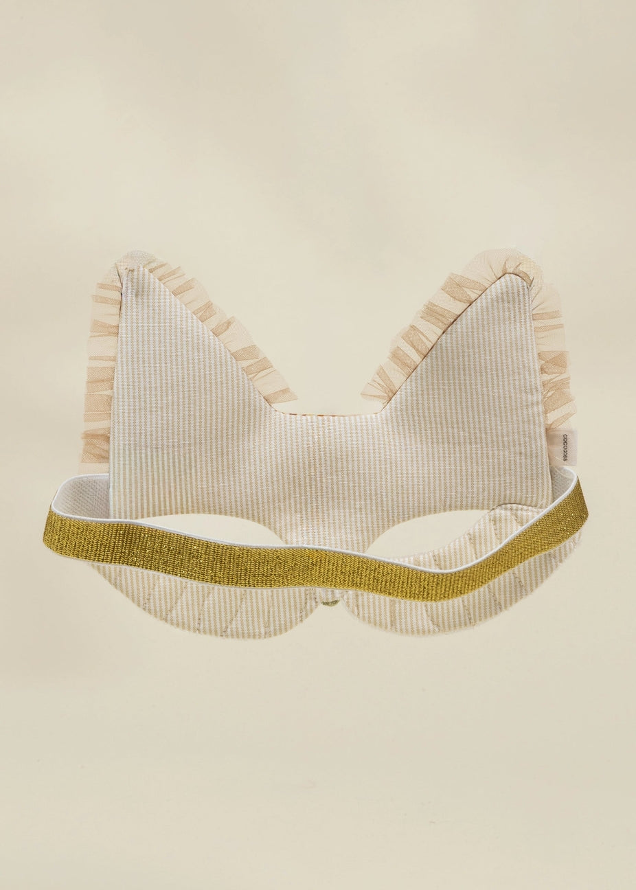 A cream-colored cat ear headband with vertical stripes, featuring a textured gold glitter band and ruffled trim, shown against a solid cream background.