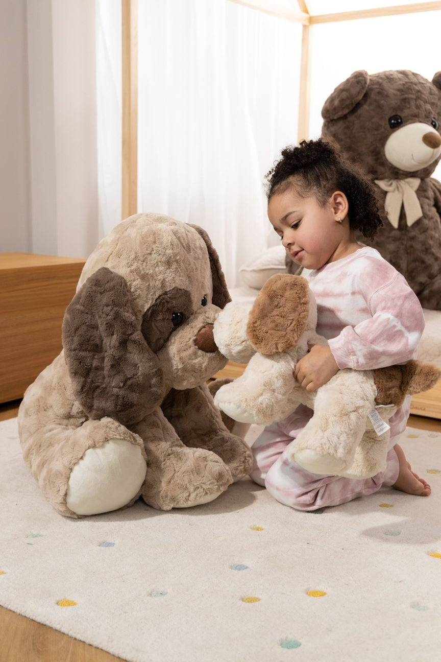 Child playing with large plush toys on a carpeted floor