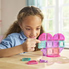 Child playing with magnetic building toys on a table