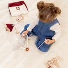Child playing with toy medical set on a soft surface