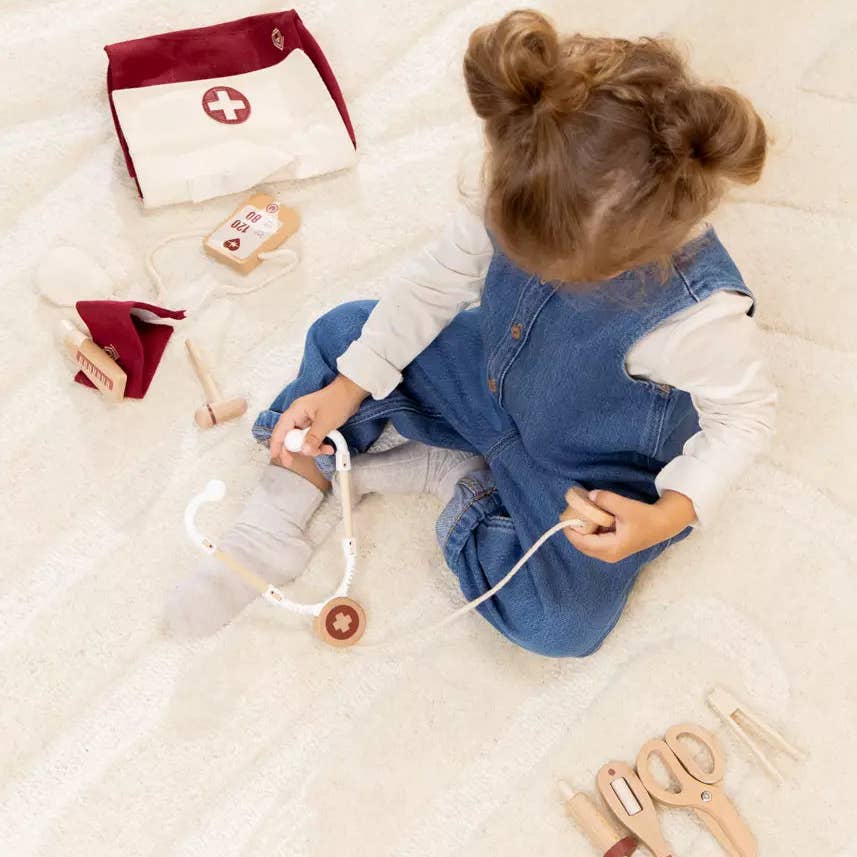 Child playing with toy medical set on a soft surface