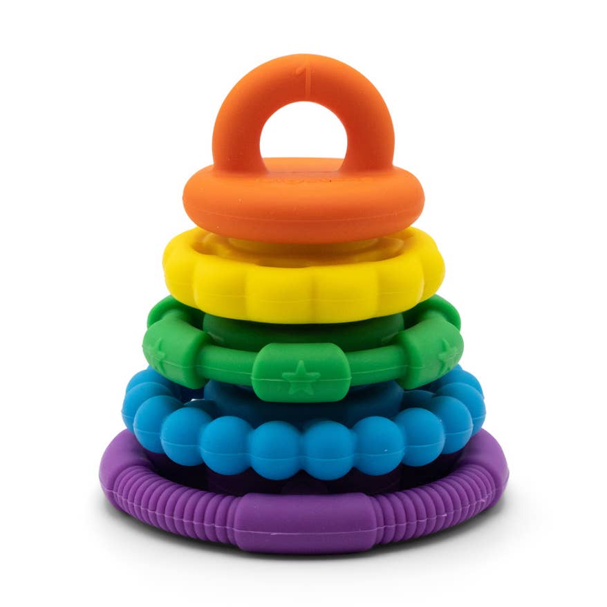 A colorful baby teething toy stack made of six stacked silicone rings in orange, yellow, green, blue, and purple, on a white background.