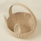 Woven basket with a handle on a beige background