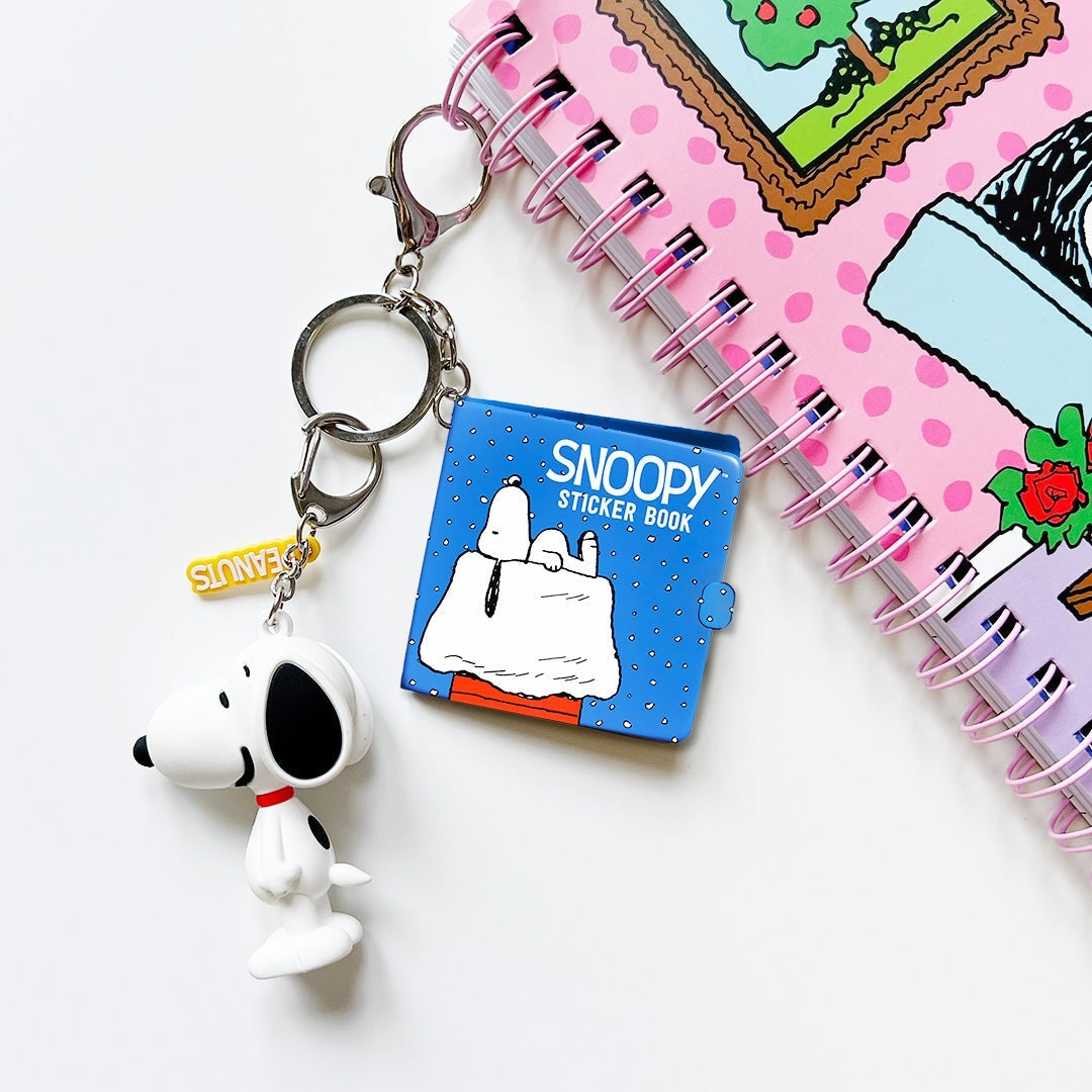 Snoopy keychain and sticker book with a polka dot notebook in the background