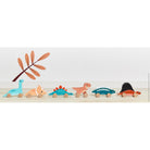 Set of colorful dinosaur toys on a wooden surface with a white background