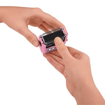 Small pink and black device held in a hand against a white background